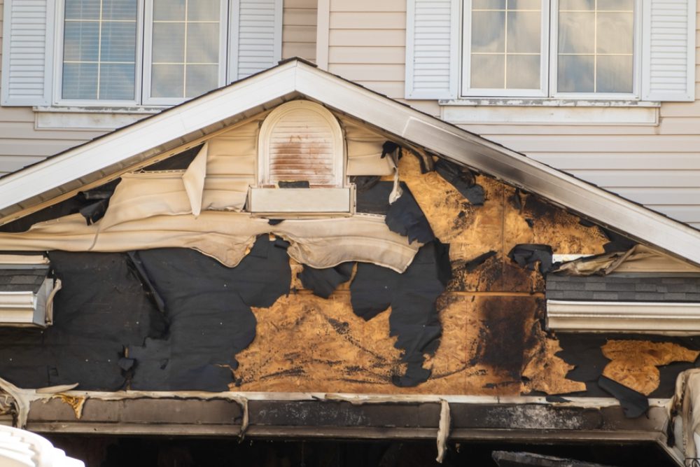 a neighborhood garage roof, which bears the scars of recent accidental fire damage